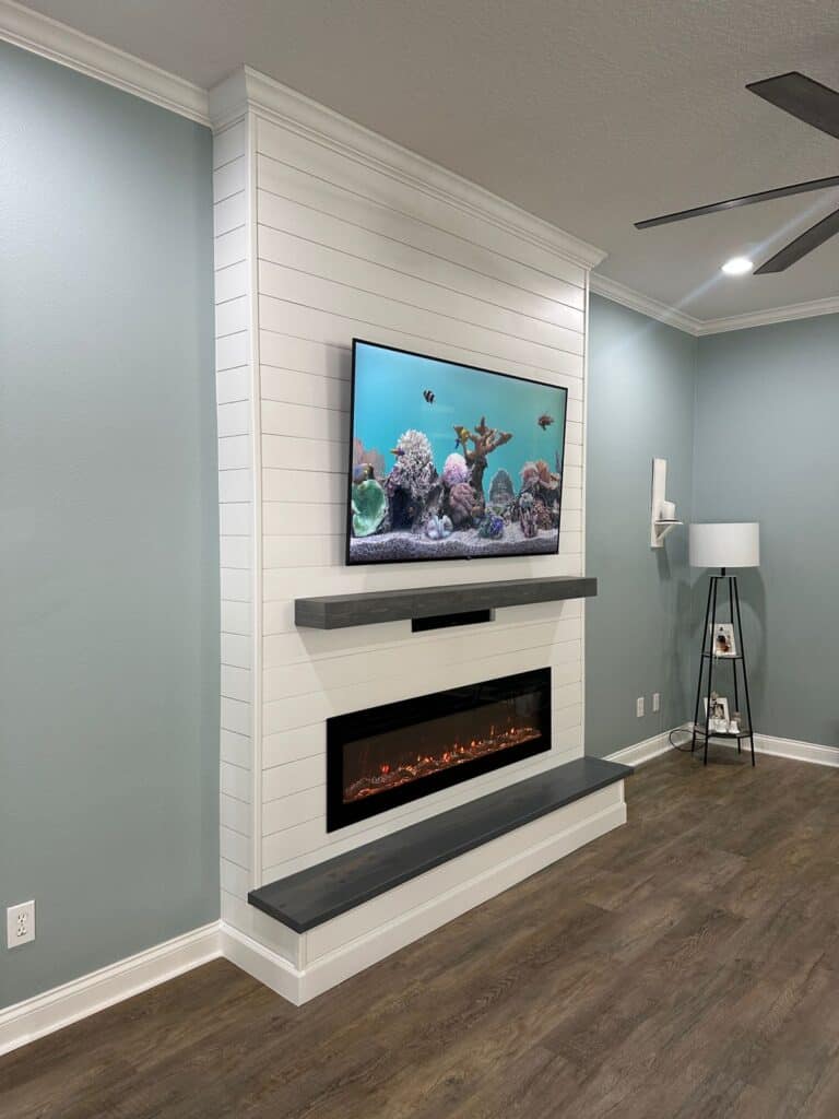 White shiplap media wall with linear electric fireplace and floating mantel