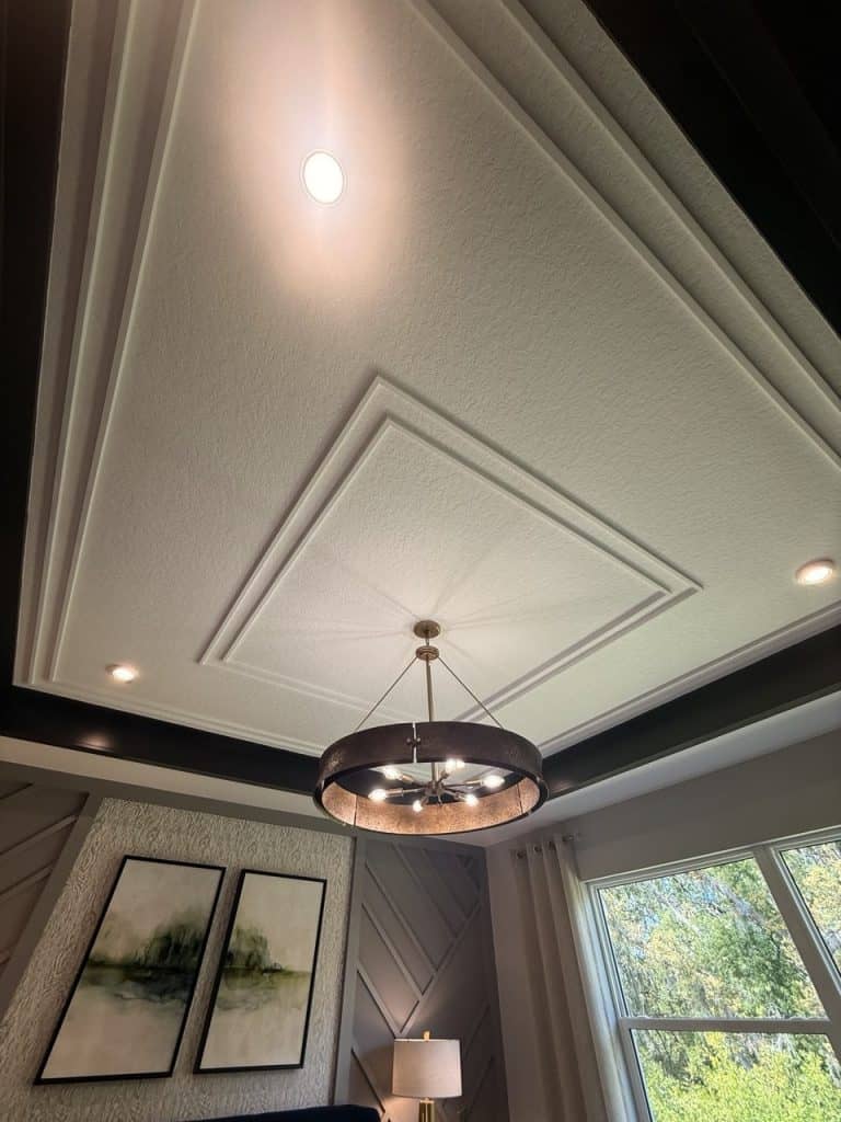 Tray ceiling with layered trim and designer chandelier