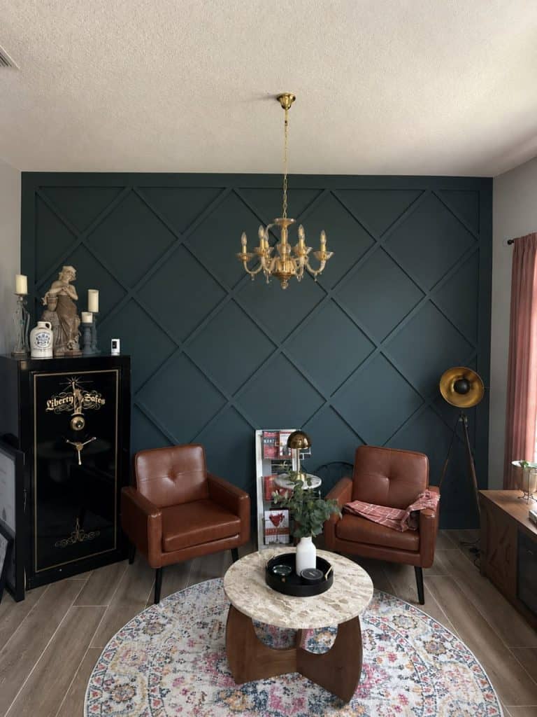 Deep teal diamond molding accent wall with gold chandelier