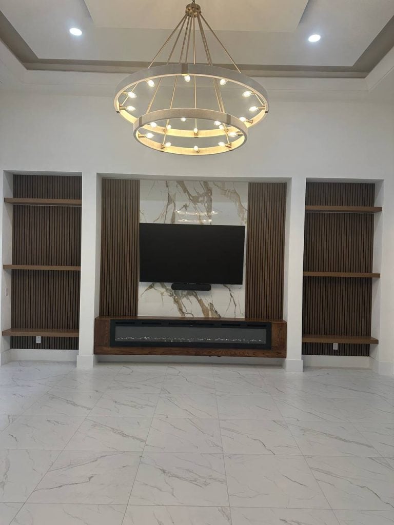 Premium marble and wood slat media wall with gold ring chandelier