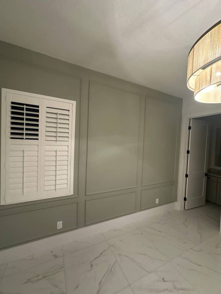 Sage green picture-frame molding accent wall