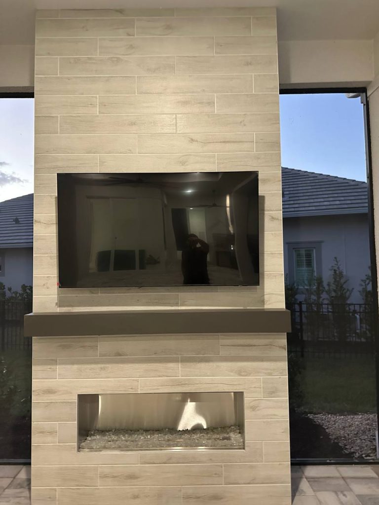 Outdoor feature wall with wood-look tile, TV and linear gas fireplace
