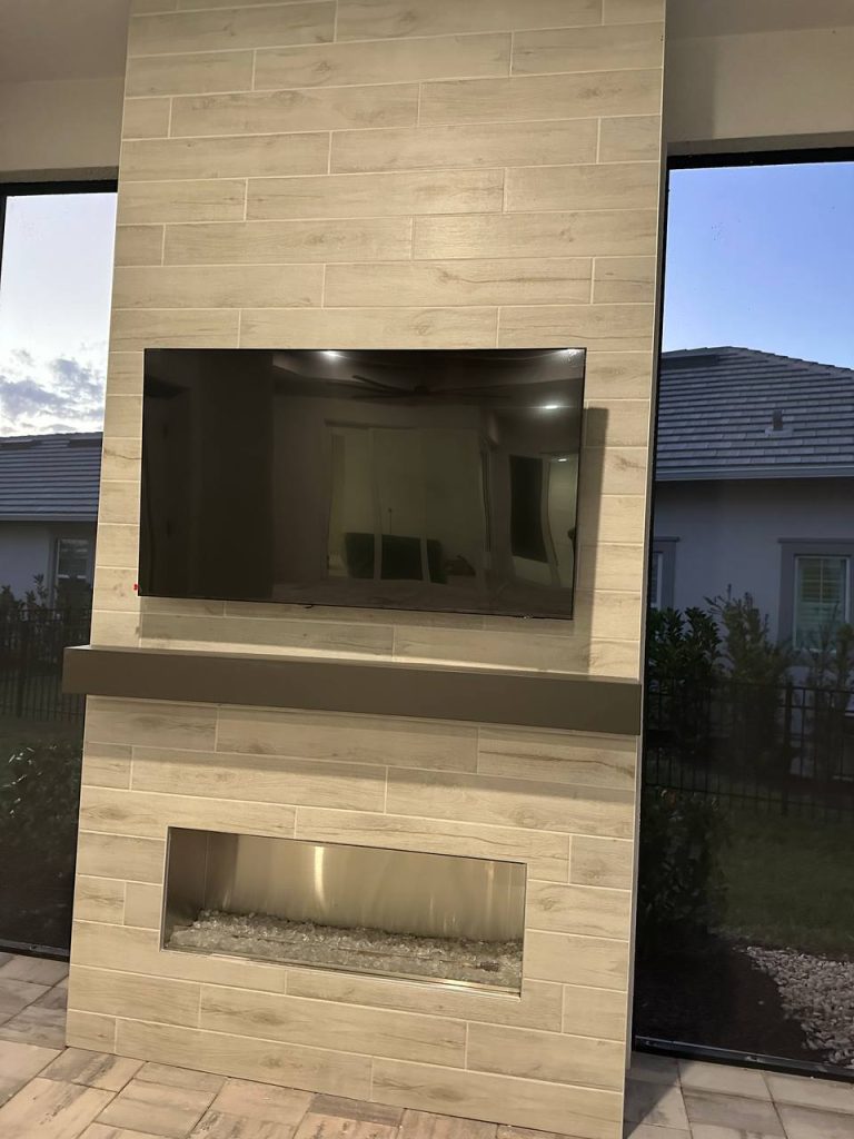 Outdoor TV and fireplace feature wall at sunset