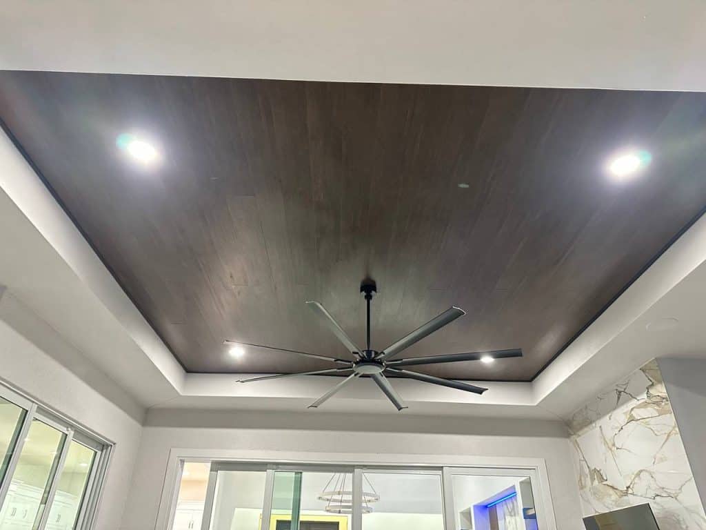 Wood plank tray ceiling with oversized ceiling fan