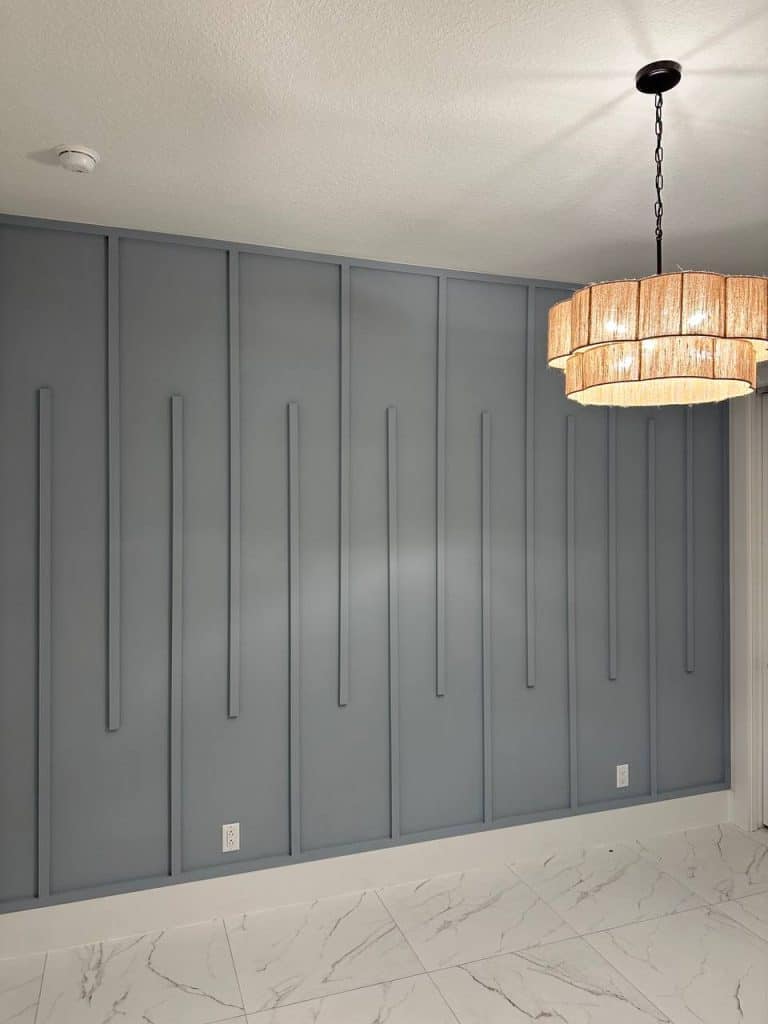 Slate blue vertical batten accent wall with woven chandelier